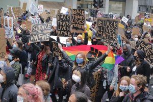 Dense cold of protesters Rainbow banner and Black Lives Matter placards